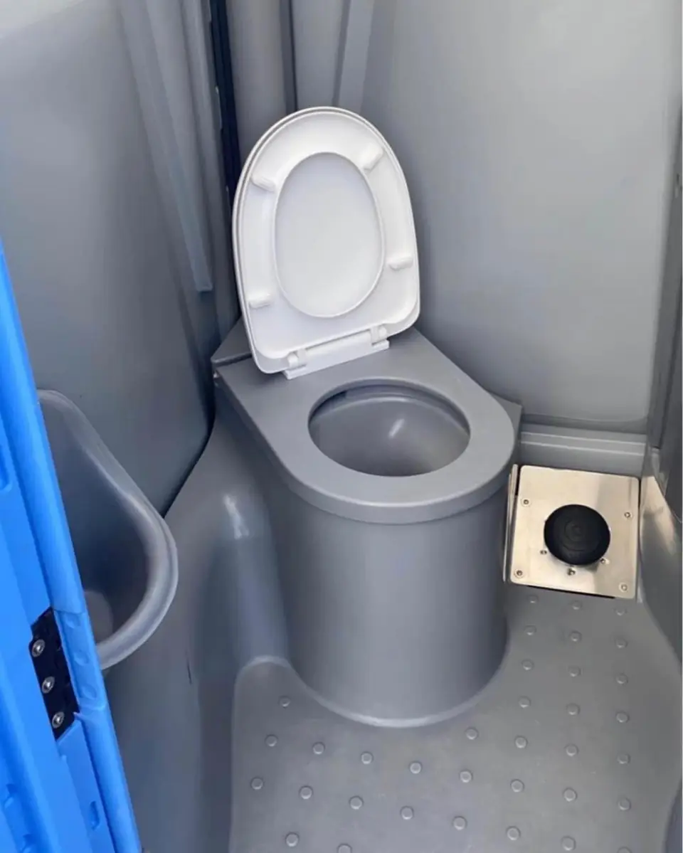 Flushing porta potty seat with lid inside a grey unit