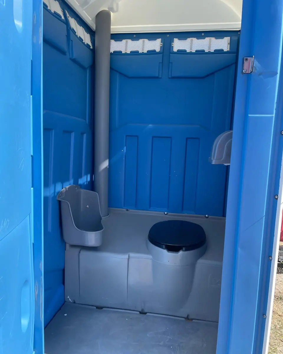 Inside a standard porta potty showing seat and urinal
