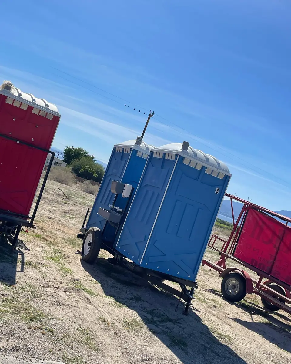 Towable porta potty trailer parked on a construction lot