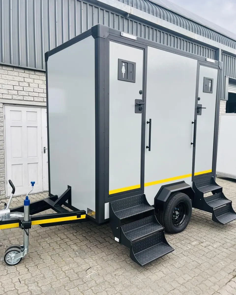 Two-station restroom trailer with steps and men and women doors